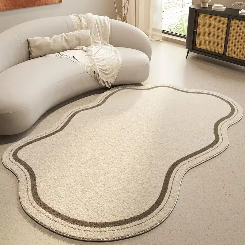 Beige rug with wavy pattern on a light-colored floor next to a gray sofa.